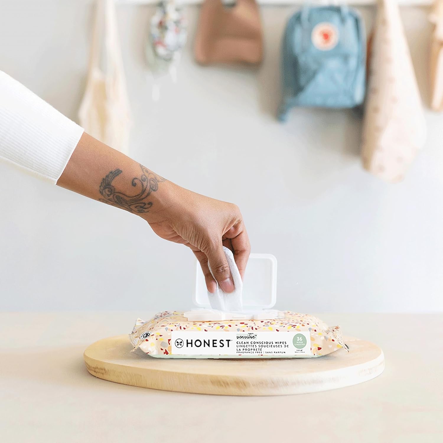Person holding The Honest Company baby wipes, featuring hypoallergenic baby wipes for sensitive skin in clear packaging.